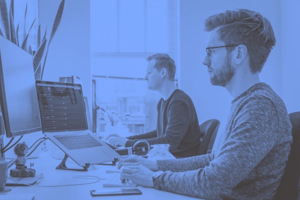 Proposal professional using AI software to write a business proposal on a laptop.